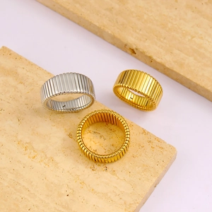 Macro detail of wide Tubogas ribbed stainless steel rings in gold and silver finish