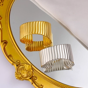 Vue détaillée des manchettes larges à texture ondulée verticale en finis or et argent
