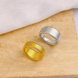 Minimalist wide ribbed stainless steel rings in gold and silver on stone base