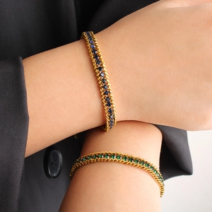 Détail de bracelets en acier doré 18K avec zircons cubiques bleus et verts brillants