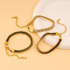 Détail de bracelets en acier inoxydable doré avec des zircons blancs, verts et bleus
