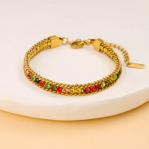 Détail d'un bracelet double chaîne en acier inoxydable doré avec zircons multicolores
