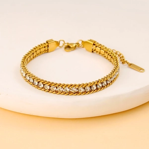 Détail d'un bracelet en acier doré avec zircons blancs étincelants et fermoir mousqueton robuste