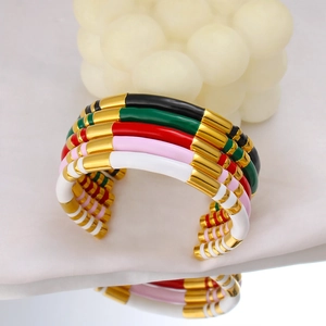 Close-up of colorful enamel bamboo style open bangles in gold-plated stainless steel
