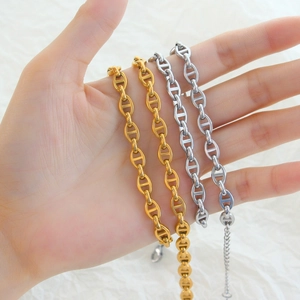 Detail of gold and silver coffee bean link chains in polished 18K plated stainless steel