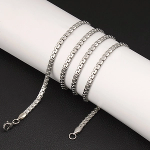 Macro view of silver flat-link stainless steel chain necklace with lobster clasp closure