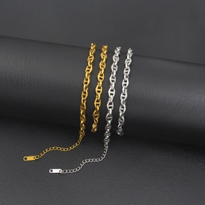 Macro detail of gold and silver pig nose link bracelets with 18KGP engraving on charms