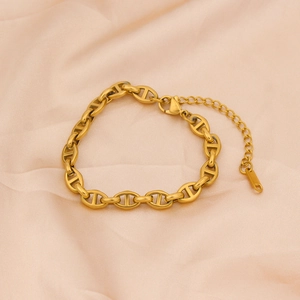 Close-up of gold titanium steel anchor link bracelet with lobster clasp on silk fabric