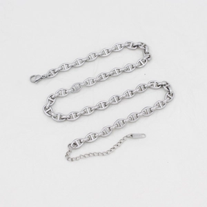 Macro detail of silver anchor link chain necklace with lobster clasp and 18KGP tag