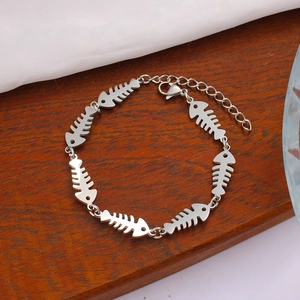 Detailed close-up of a silver fishbone chain bracelet with adjustable lobster clasp and links