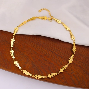 Detail of golden fishbone chain necklace with lobster clasp on silk and wood