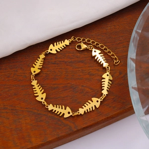 Detailed close-up of 18K gold-plated herringbone bracelet with lobster clasp on wood
