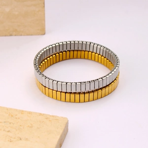 Détail de bracelets élastiques dorés et argentés avec maillons métalliques texturés