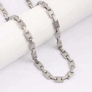Close-up of textured stainless steel link chain with industrial embossed tree bark pattern