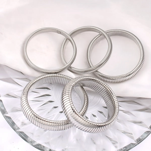 Detailed view of silver Tubogas stretch bracelets in five-piece set on white satin