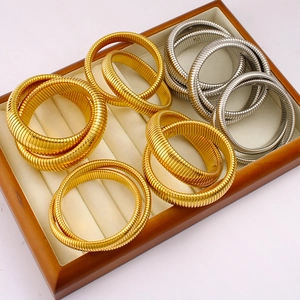Flexible spiral stainless steel bracelets in gold and silver colors stacked in a gift box