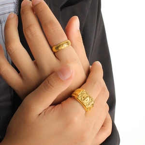 Gold-plated stainless steel floral rings and signet ring set on male hand with suit