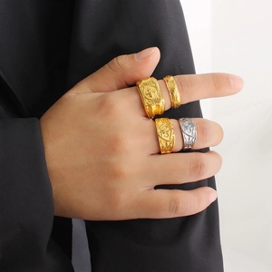 Close-up of model wearing punk style 18K gold and silver rings with floral patterns