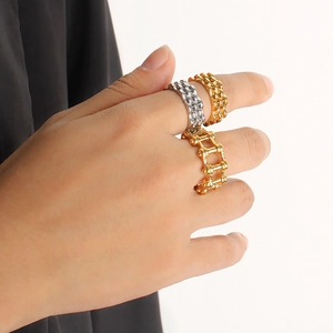 Detail of 18K gold and silver stainless steel gear chain rings on model fingers