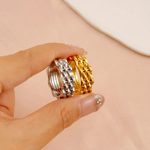 Hip hop chain style rings in silver and gold plating shown on hand for women