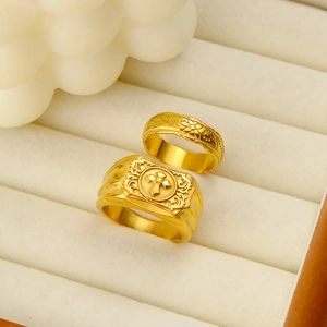 Macro shot of 18K gold plated rings with cross and floral engraved patterns in a display box