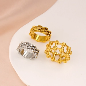 Macro detail of industrial style bike chain rings in polished gold and silver finish
