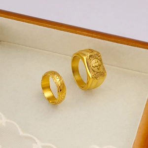 Detail of 18K gold plated rings featuring vintage cross and floral relief patterns