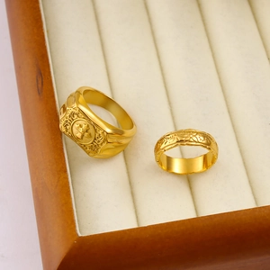 Detailed macro view of 18K gold plated rings with floral patterns in a jewelry box
