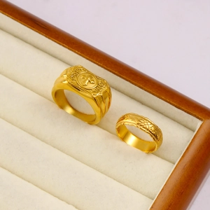 Detail of 18K gold plated rings with cross and floral engravings in a velvet box