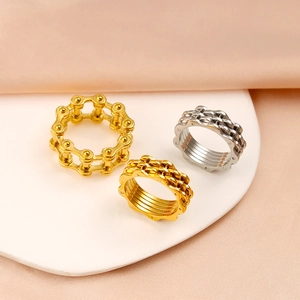 Detail of industrial bicycle chain rings and gear textured bands in gold and silver