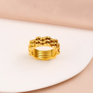 Detail of 18K gold-plated gear-style stainless steel ring with industrial chain design