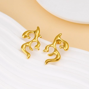 Macro shot of gold irregular liquid metal earrings on a minimalist white stand