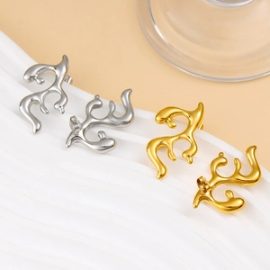 Macro detail of abstract lava design stud earrings in polished gold and silver finishes
