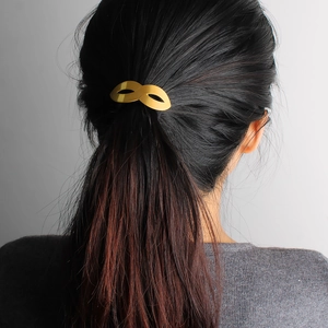 Hip hop style gold hollow metal hair tie accessory shown on a brunette ponytail