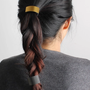 Minimalist rectangular gold and grey metal hair ties shown on hair from back view