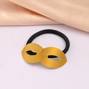 Polished 18K gold-plated figure-8 metal elastic hair tie on silk fabric background