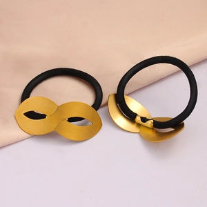Detail of high-elasticity black hair ties with brushed gold infinity metal accents