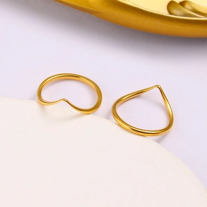 Vue macro de deux bagues dorées minimalistes en forme de V avec finition polie