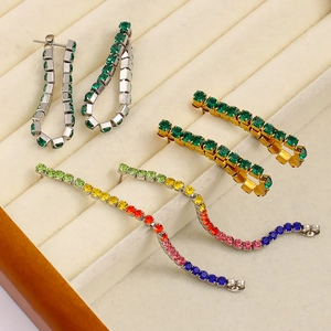 Dettaglio di orecchini pendenti con strass colorati placcati in oro e argento