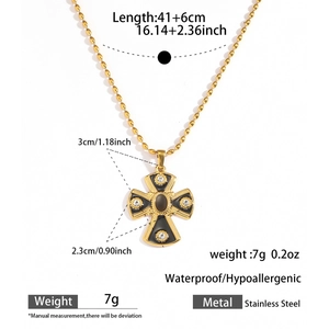 Detail of gold stainless steel cross pendant with black enamel and zircons for women