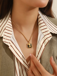 Detailed view of a vintage gold necklace with black enamel pendant and swallow relief