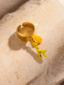 Macro shot of 18k gold plated wide open ring with giraffe pendant, pearl and flower charm