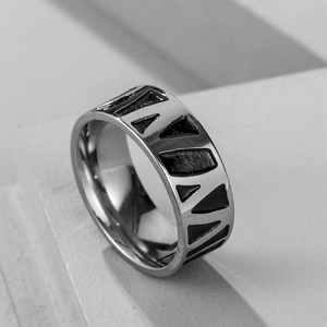 Macro shot of stainless steel wide band ring with black triangle geometric pattern