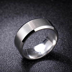Macro shot of brushed stainless steel men's ring with polished beveled edges and matte texture