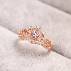 Macro di un anello a corona in oro rosa con zirconi in una scatola di velluto