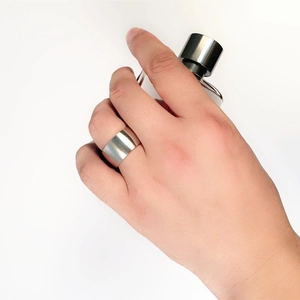 Nahaufnahme eines 12mm breiten polierten 316 Titanstahlrings am Finger in Silberoptik