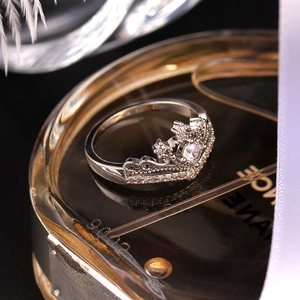 Dettaglio macro dell'anello a corona con zircone scintillante su boccetta di lusso