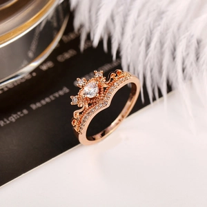 Dettaglio macro di anello a corona in oro rosa con grande zircone rotondo e pavé di pietre