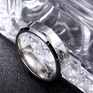 Macro shot of silver titanium steel ring with double beveled edges on black background