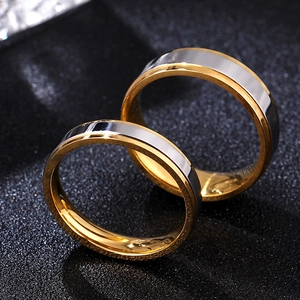 Macro shot of two-tone couple rings with silver brushed surface and gold polished edges
